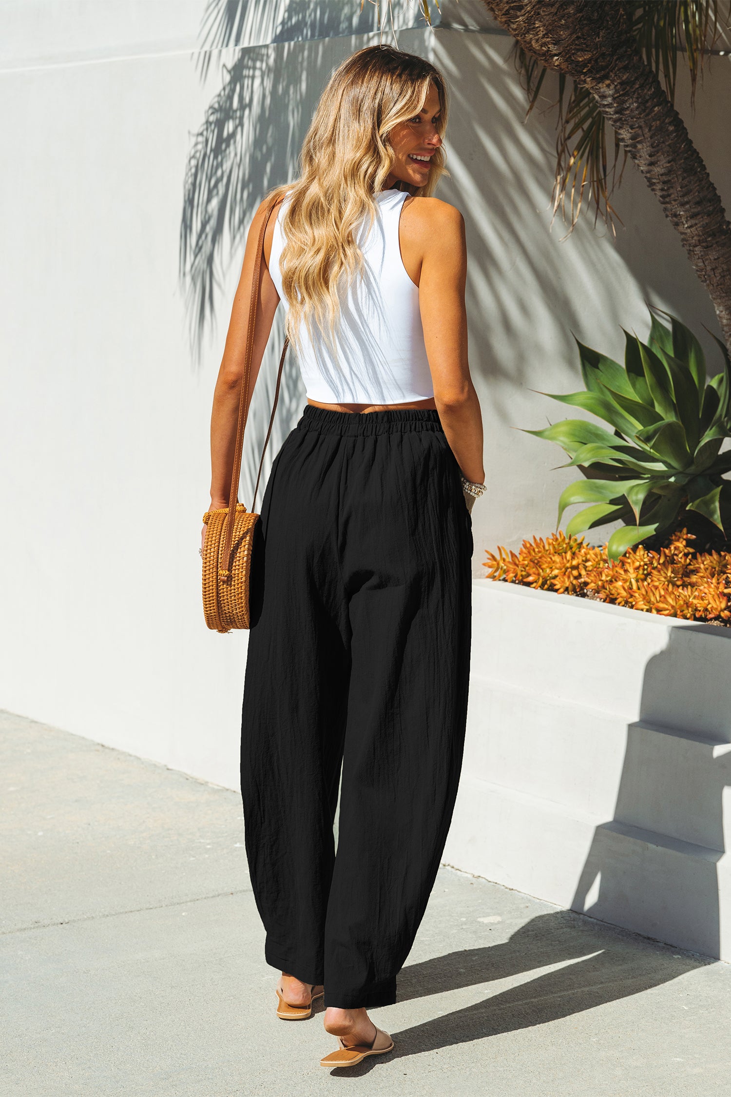 Schwarze Hose mit spitz zulaufendem Bein und elastischer Taille